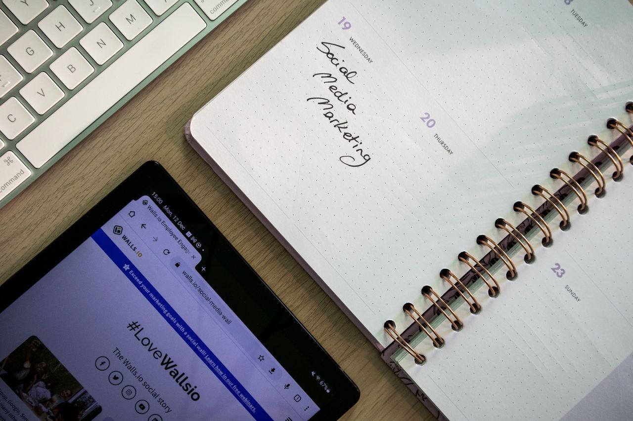 about-002 Vue de dessus d’un carnet, d’une tablette et d’un clavier utilisés pour la planification du marketing sur les réseaux sociaux.